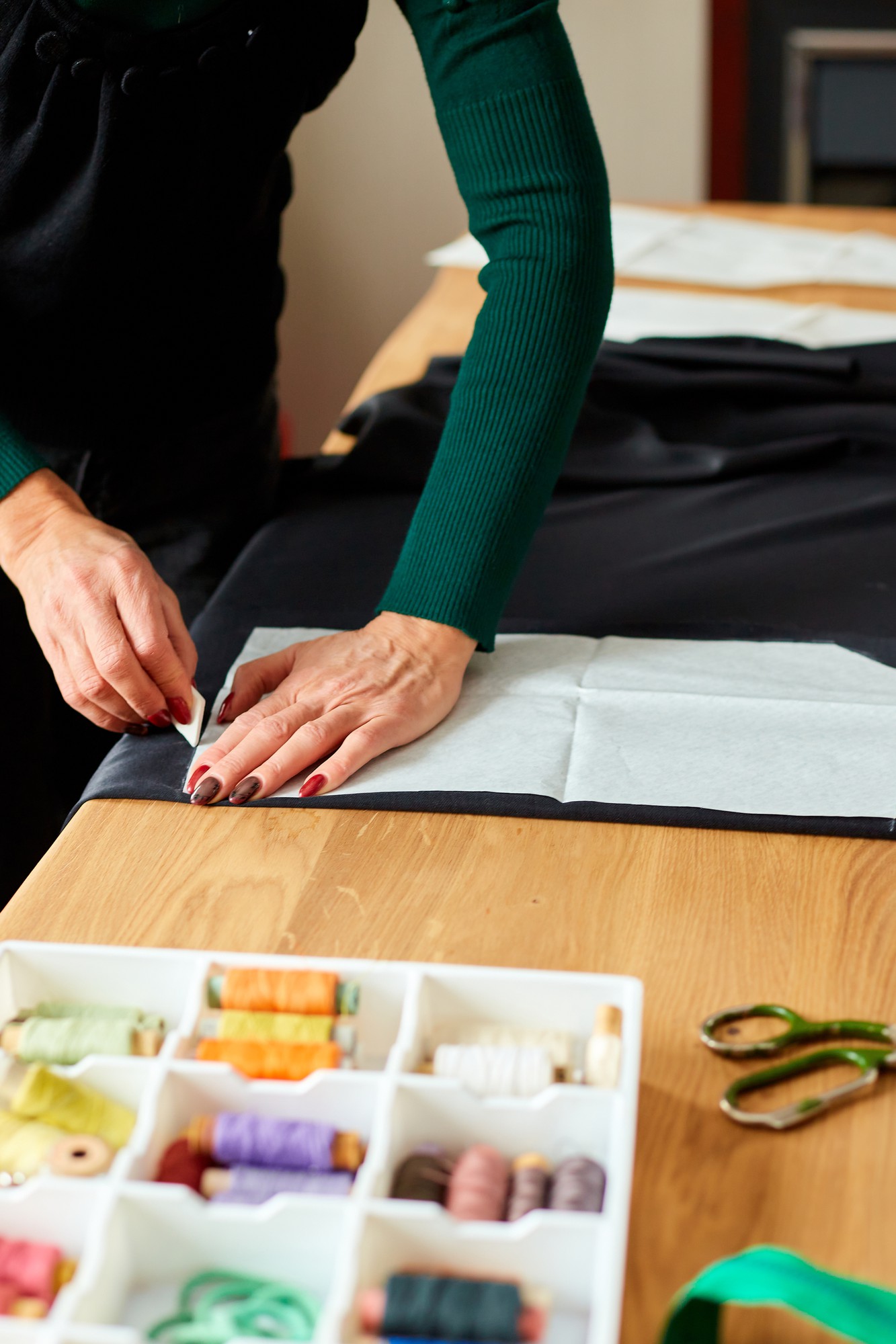 Teacher preparing threads and fabric in studio